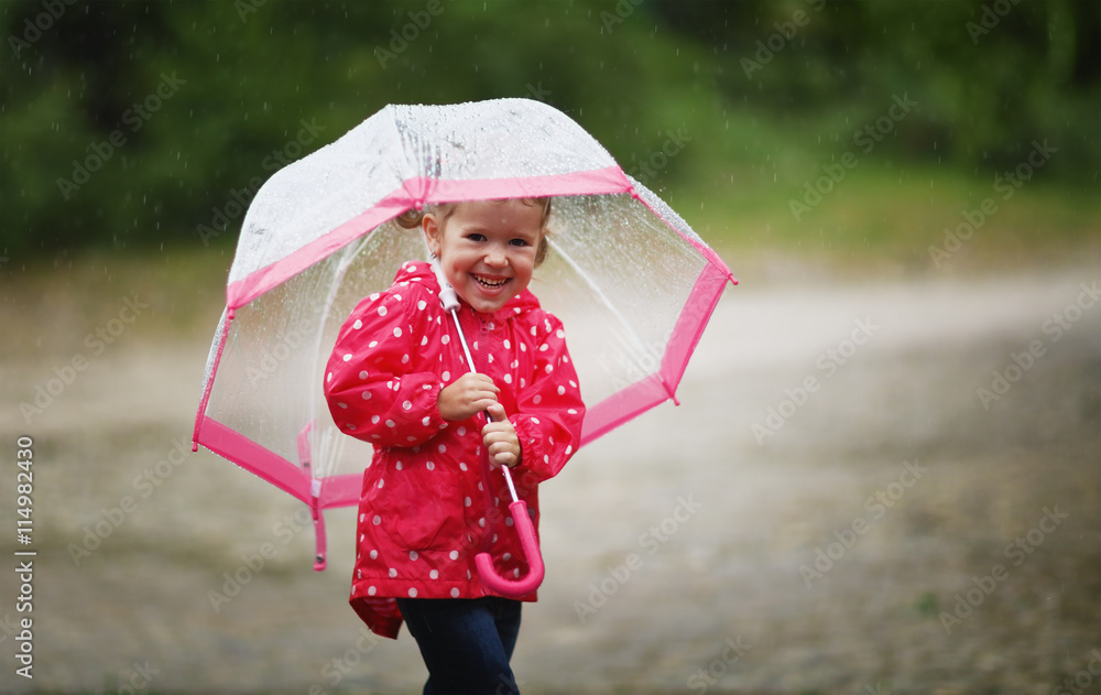 快乐的小女孩在雨中撑着伞大笑