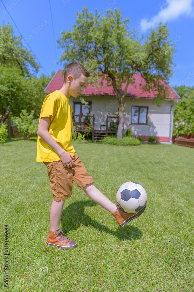 在绿色草坪上打球的男孩。夏天！