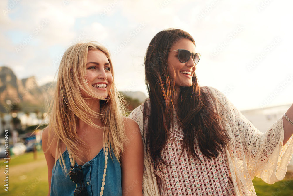 快乐的年轻女性朋友一起在海滩上