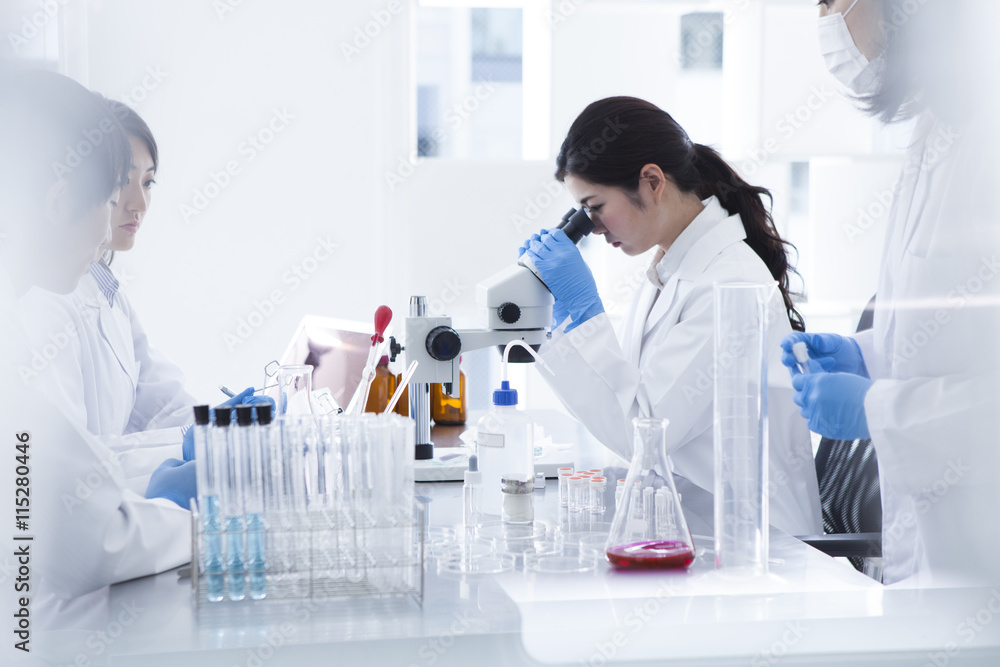Woman looking through a microscope in a laboratory