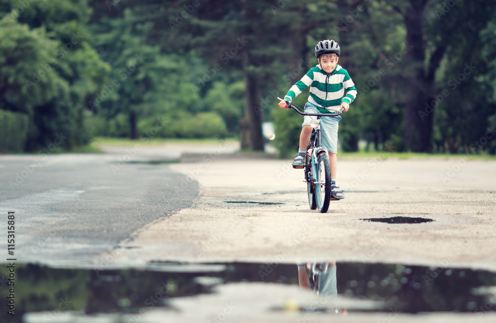 夏天在柏油路上骑自行车的孩子