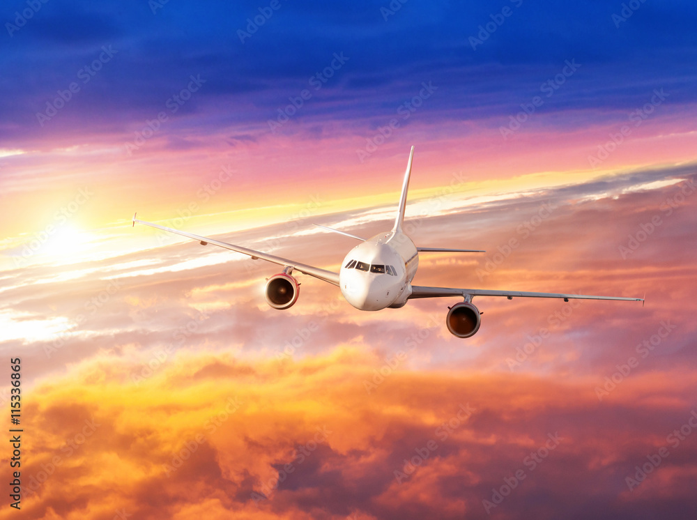 在戏剧性的日落中，飞机在云层上方飞行