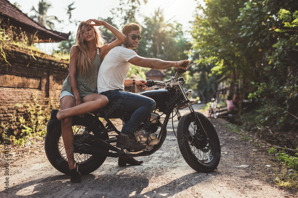 一对夫妇骑着摩托车在乡下闲逛