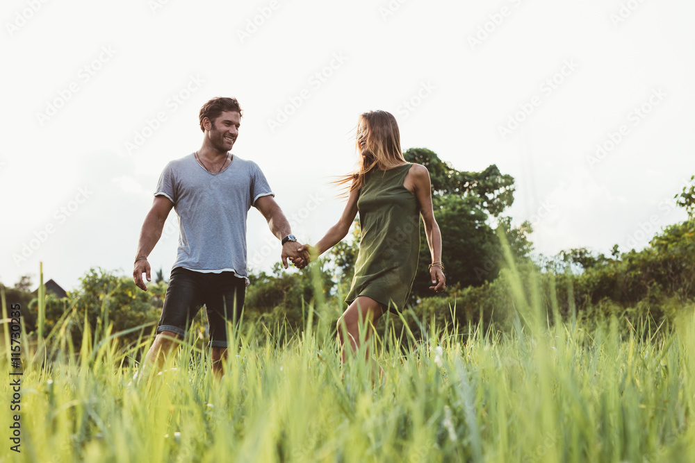 一对年轻夫妇在高高的草地上行走