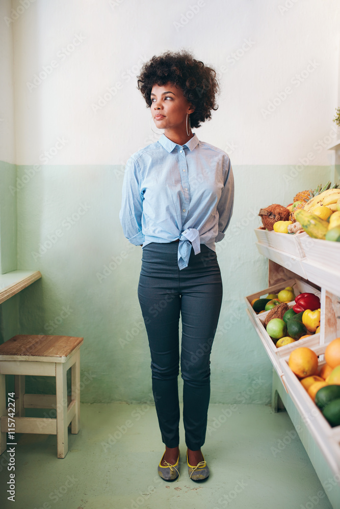 年轻的非洲女人站在果汁吧里