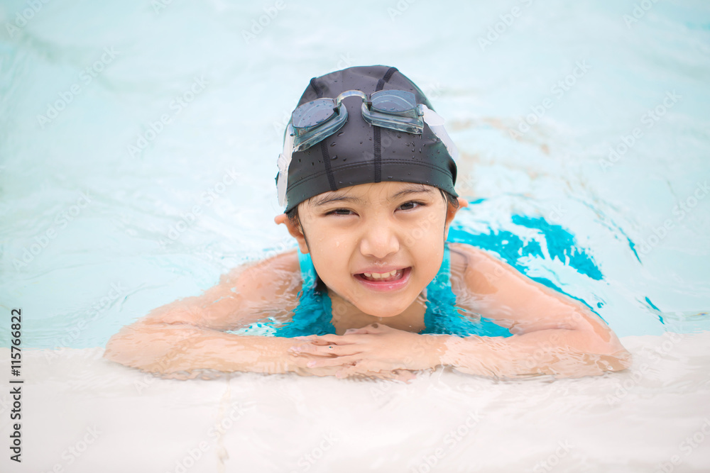 Happy Asian girl swimming in the swimming pool