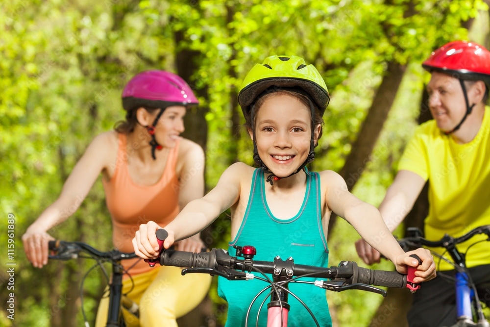 骑自行车时与父母在一起的少女