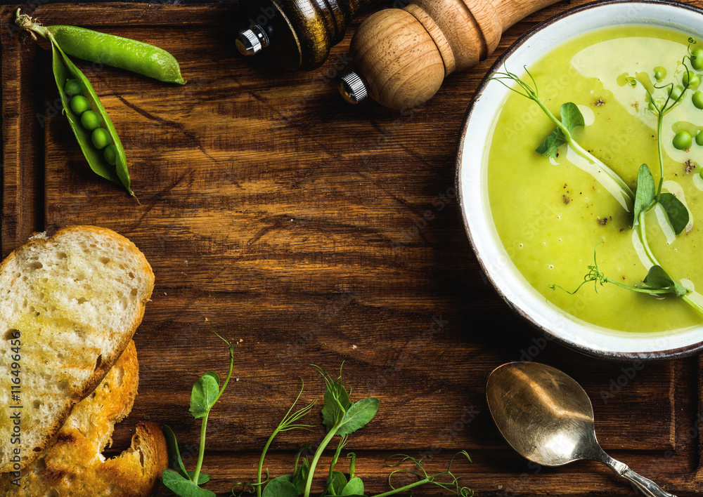 浅夏绿色豌豆奶油汤，碗里有芽菜、烤面包和香料，配以乡村木b