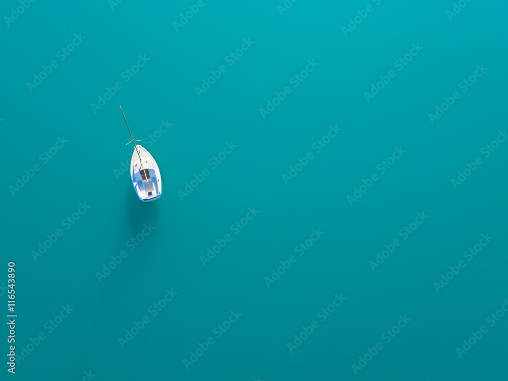 独自一艘游艇在蔚蓝的水面上航行的鸟瞰图