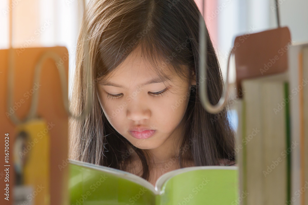 亚洲小女孩在学校图书馆看书