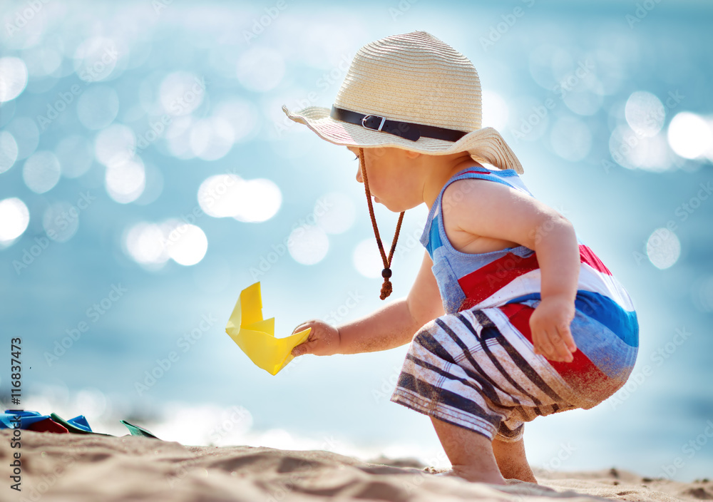 戴草帽在海滩玩耍的小男孩