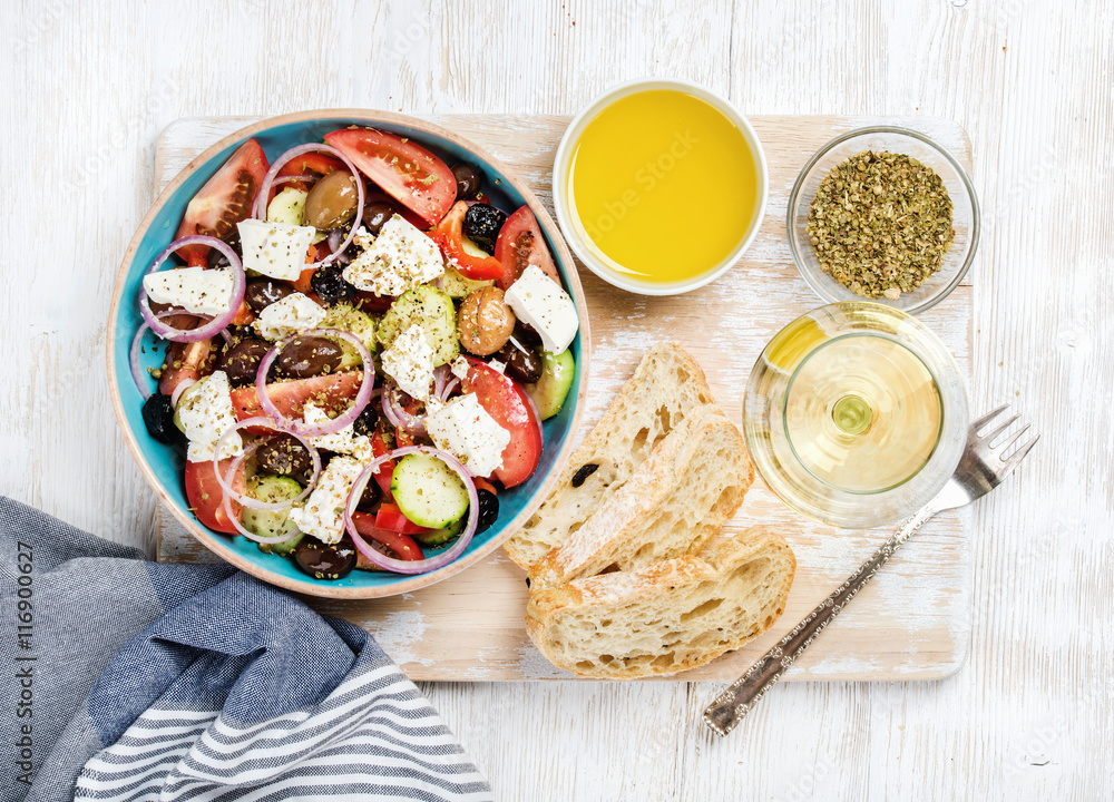 希腊沙拉配橄榄油、面包、牛至和一杯白葡萄酒，配古老的白漆木蟒蛇