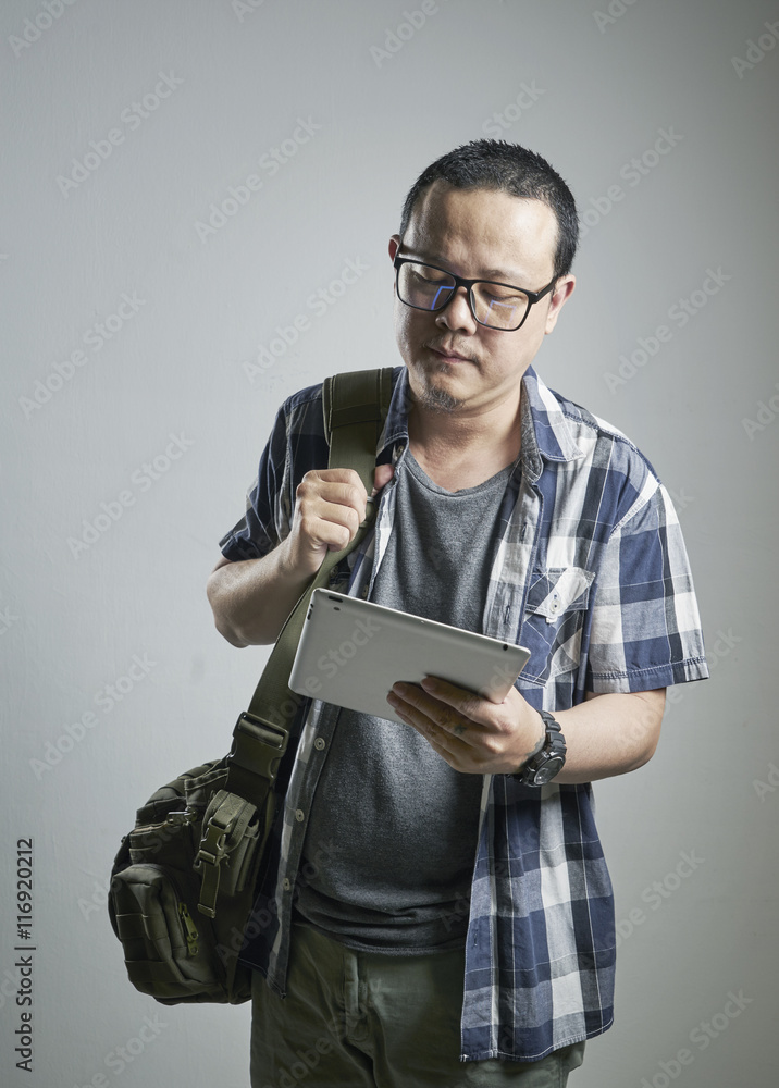 一个压力重重的亚洲男人在普通背景上举着一个数字键盘的肖像