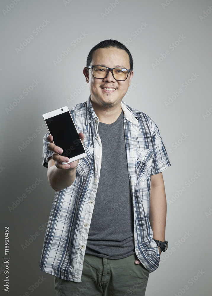 一个快乐的亚洲男人在普通背景下拿着手机的肖像