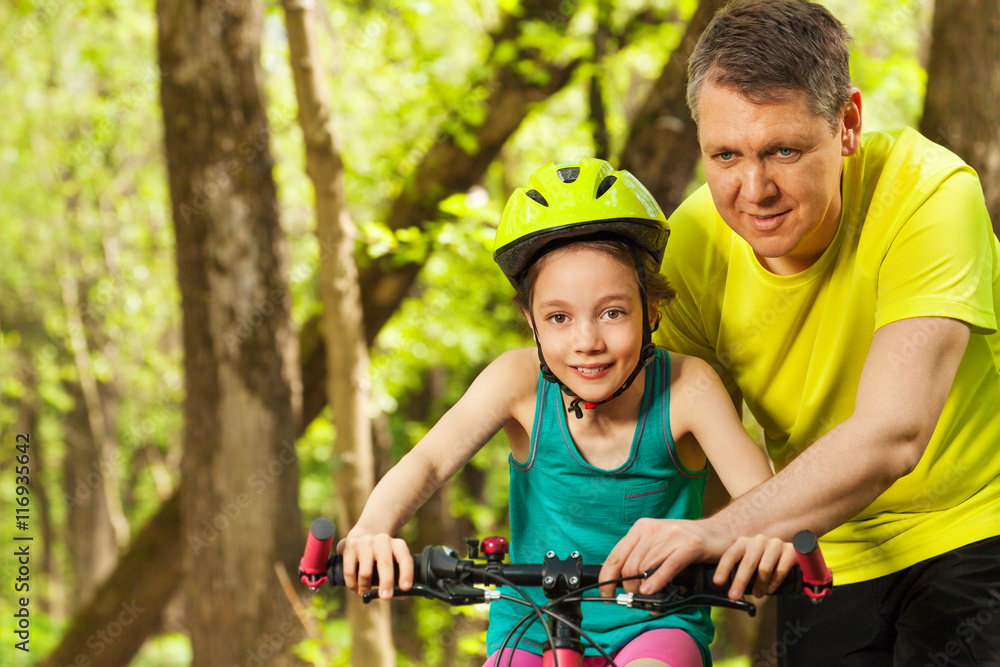 快乐女孩与父亲一起学习骑自行车