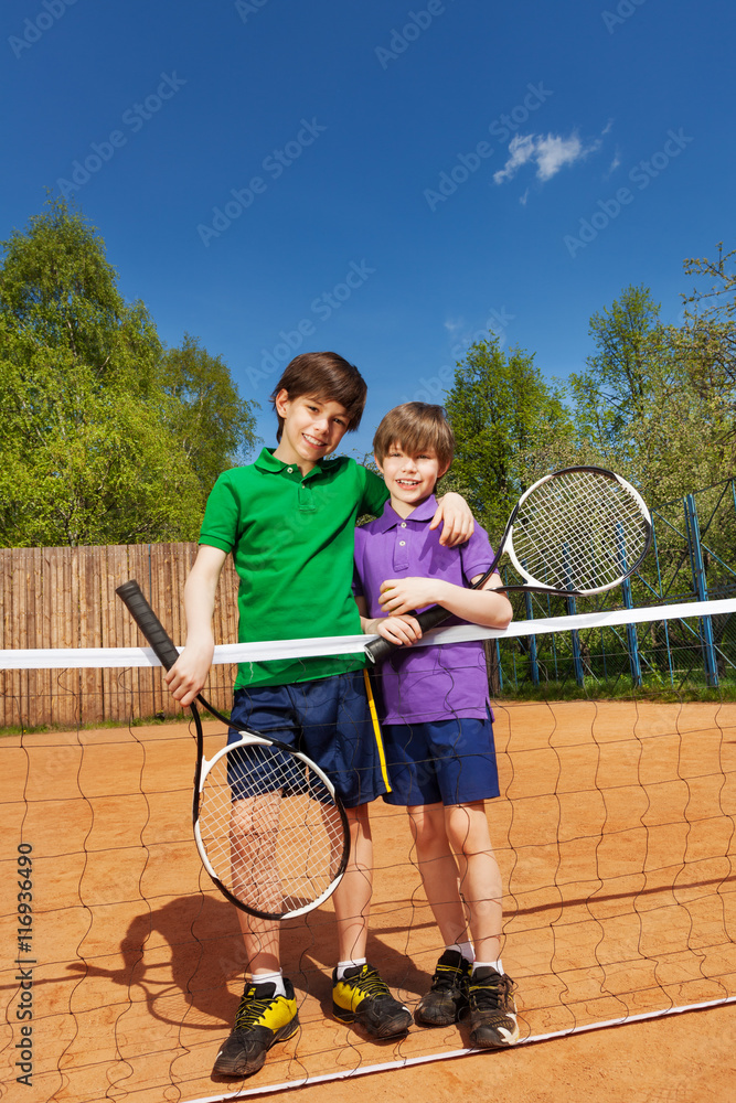 两位网球冠军站在球网旁边