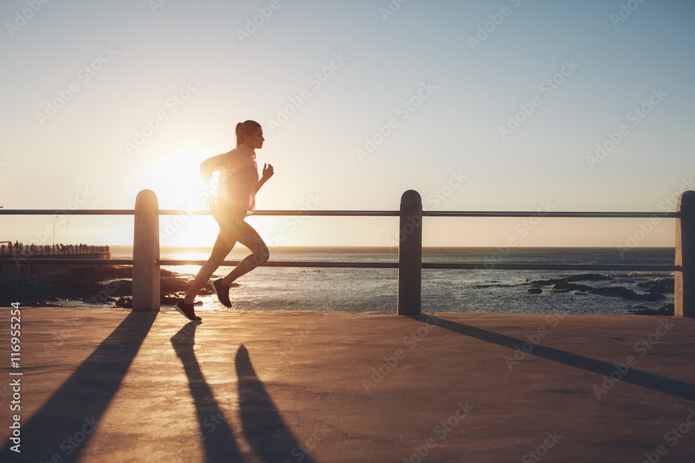 日落时分，女运动员在海滨长廊训练