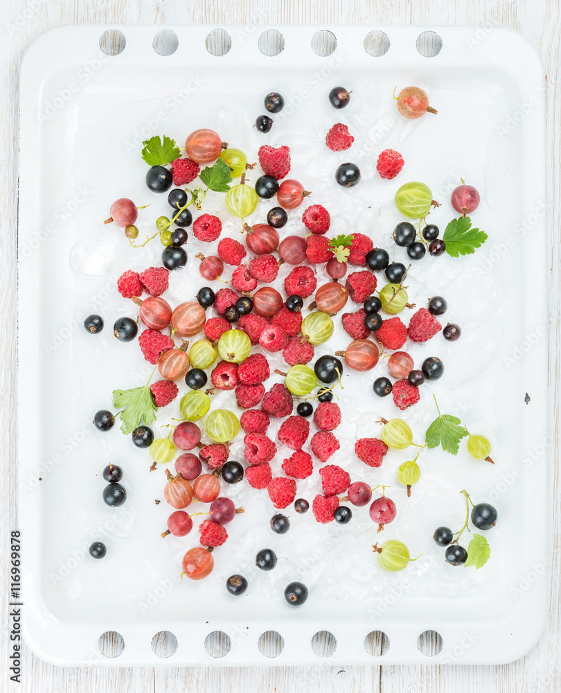 新鲜的夏季花园浆果品种放在白色烤盘上，白色木制背景，顶部为vie