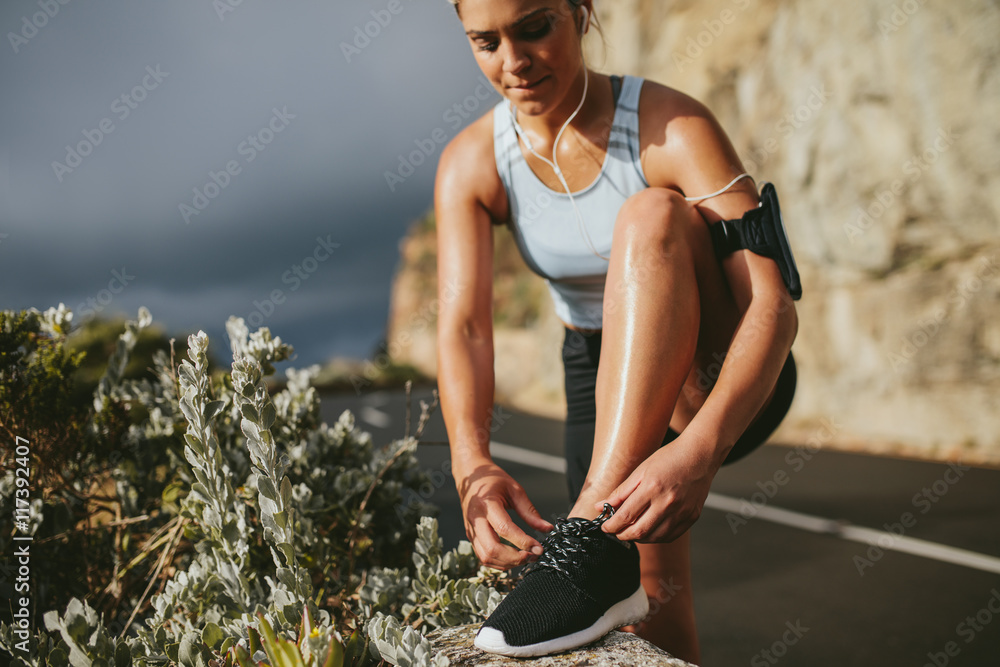 Female runner tying shoe laces