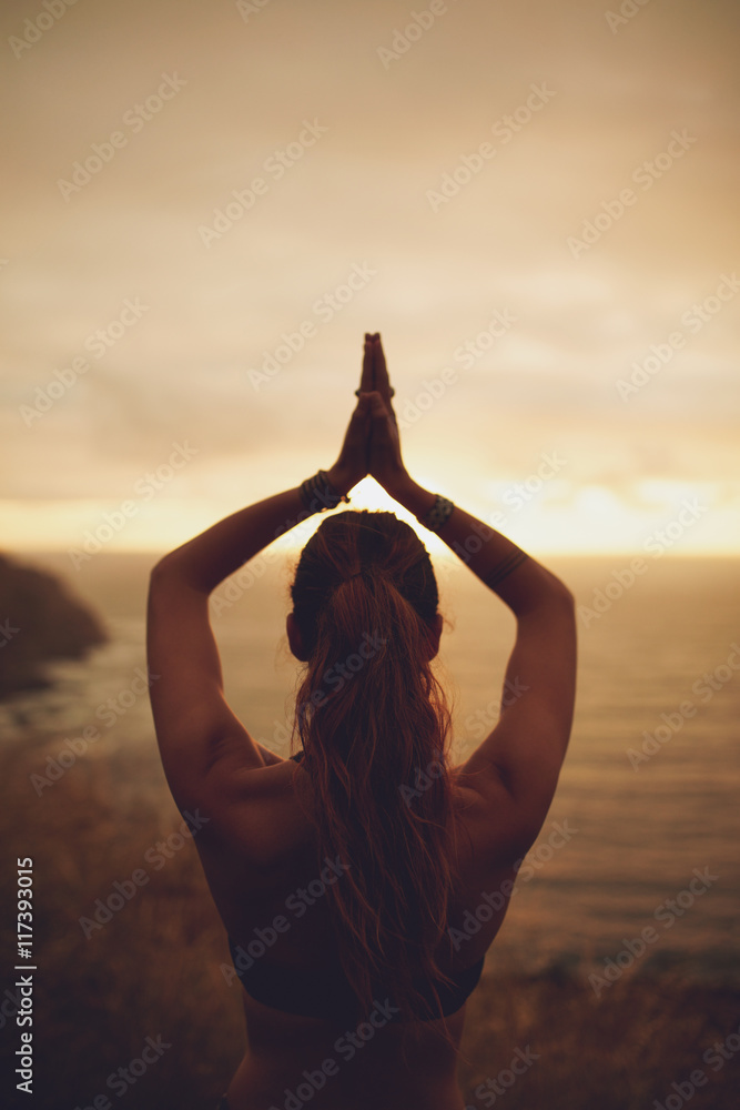 Fitness woman doing yoga during sunset