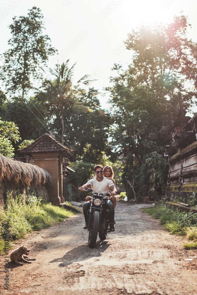 一对夫妇在乡村公路上骑摩托车。