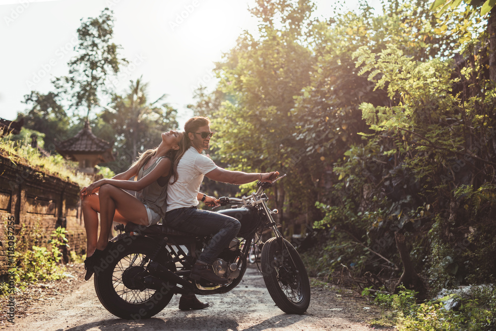 年轻夫妇坐在摩托车上