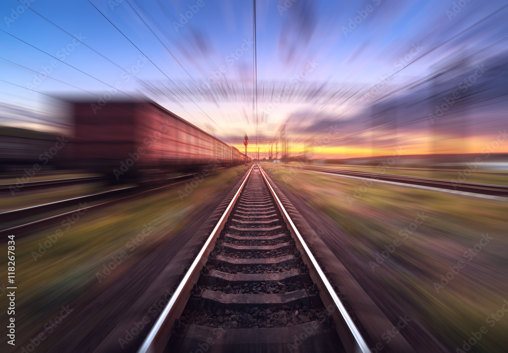 Railway station with cargo wagons in motion at sunset. Railroad with motion blur effect. Railway pla