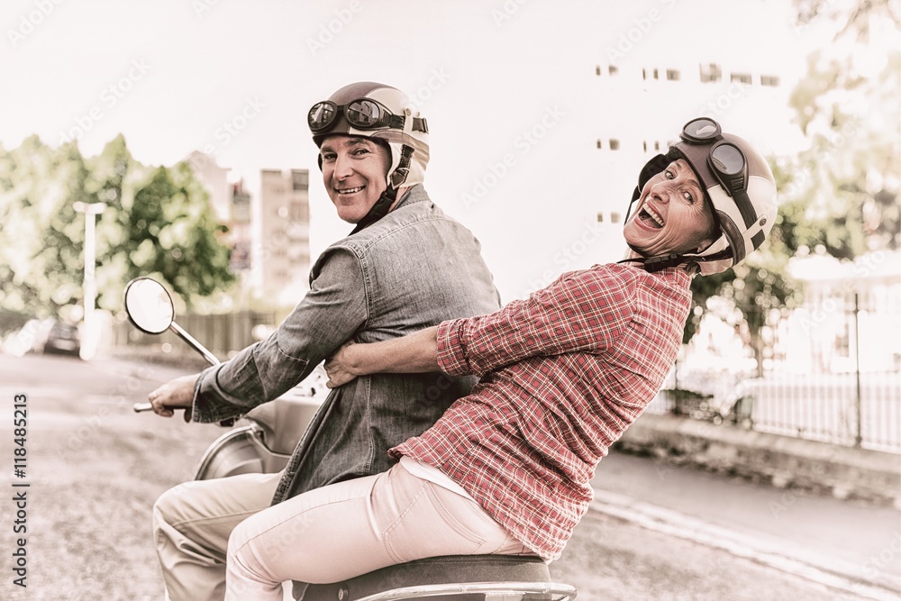 幸福的成熟夫妇在城市里骑着摩托车