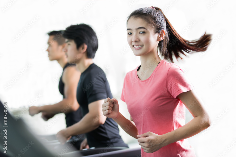 亚洲女性在跑步机上和她的fr一起跑步锻炼