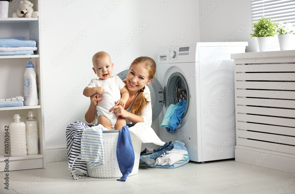 妈妈一个带着孩子的家庭主妇把衣服叠到洗衣机里