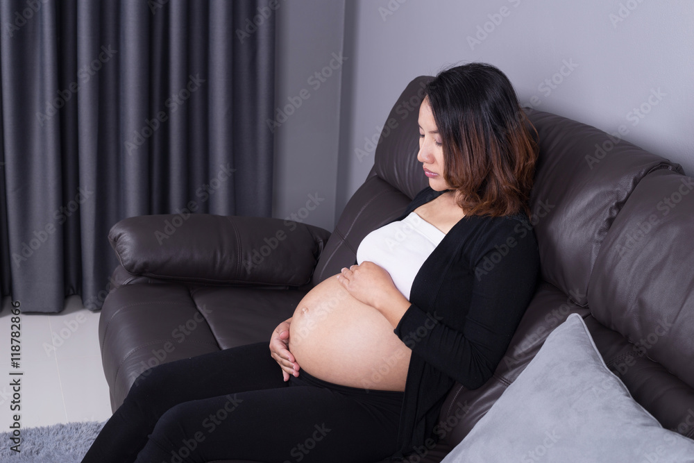 pregnant woman resting at home on sofa