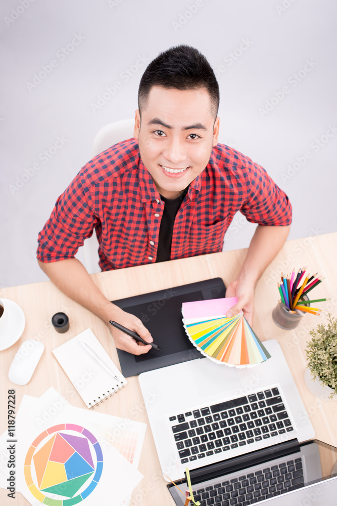 年轻男性平面设计师在办公桌上的肖像。
