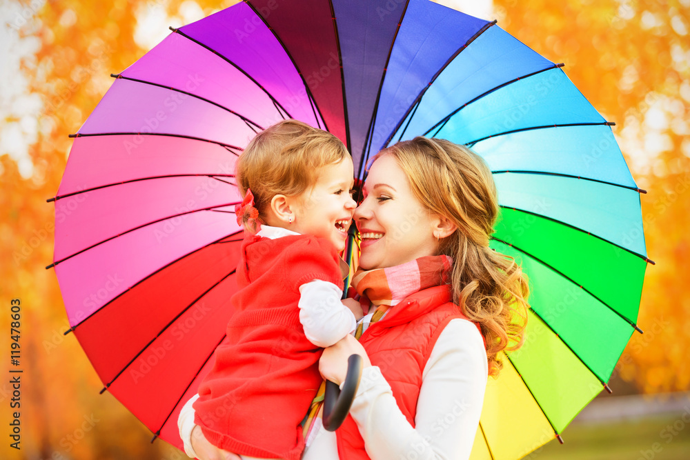 幸福的家庭妈妈和孩子的女儿与彩虹色的umbrell