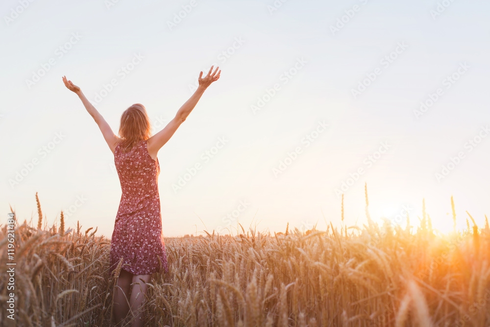 呼吸，女人举起双手在田野里欣赏日落