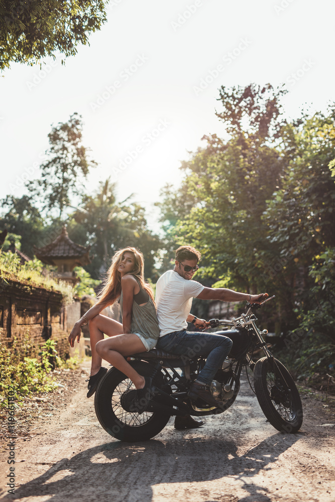 情侣骑摩托车在村道上闲逛