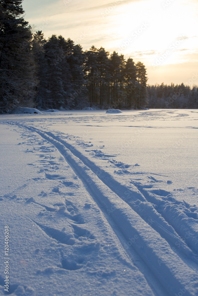 雪地里的滑雪道。滑雪道是在湖冰上的深雪中制作的。照片拍摄于日落期间