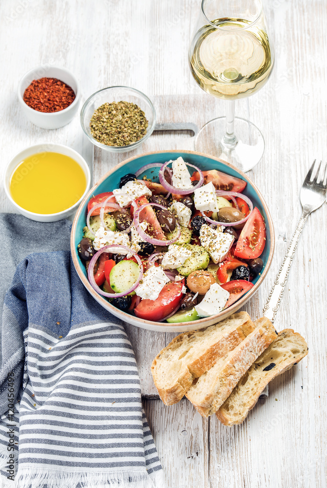 希腊沙拉配橄榄油、面包、牛至、胡椒和一杯白葡萄酒，配上古老的白漆wo