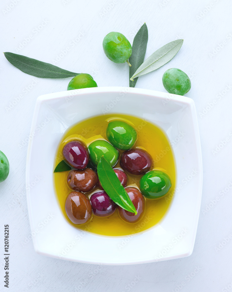 橄榄和橄榄油。在陶瓷碗中混合腌制橄榄