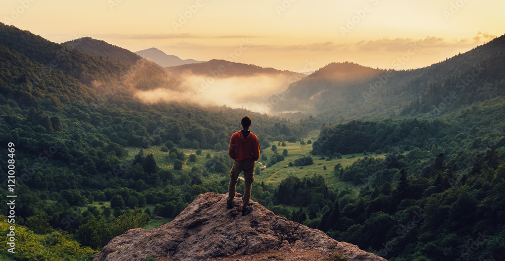 日落时分，一名男子站在悬崖顶上