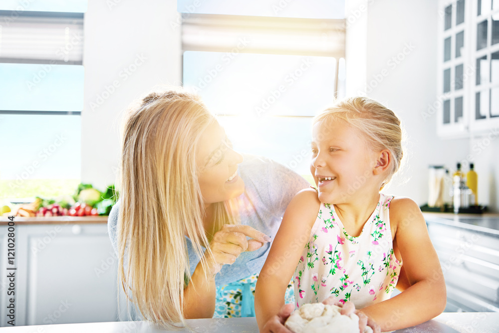 Loving mother teaching her daughter to bake