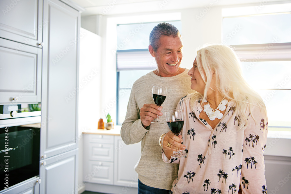 Happy retired couple enjoying a glass of wine