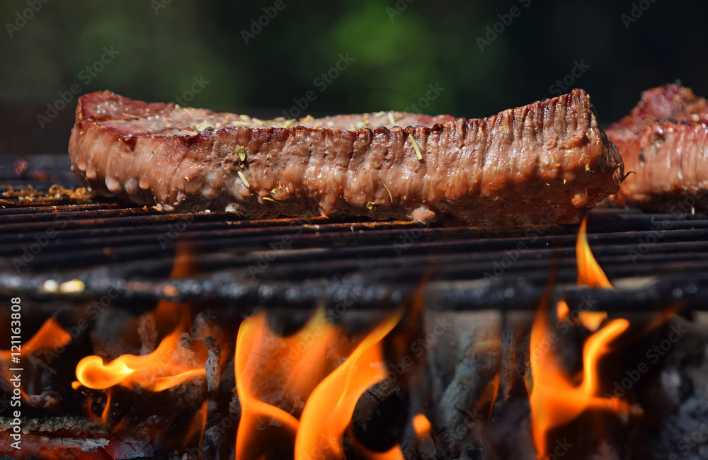 Beef steak grilled on flame barbecue fire grill