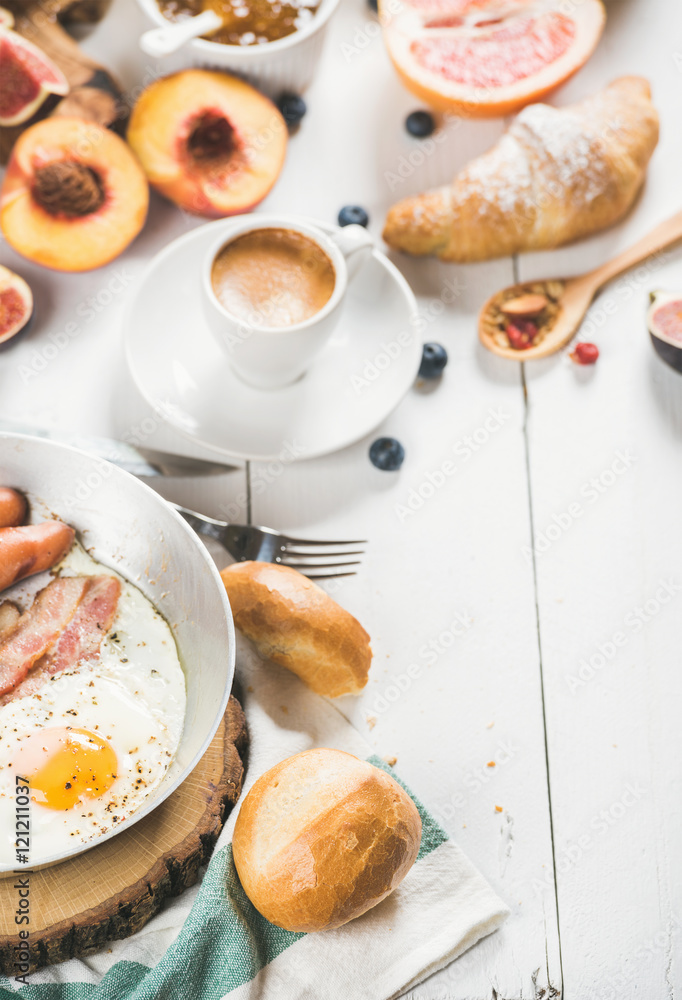 煎蛋配香肠和培根、新鲜面包、羊角面包配水果和一杯咖啡