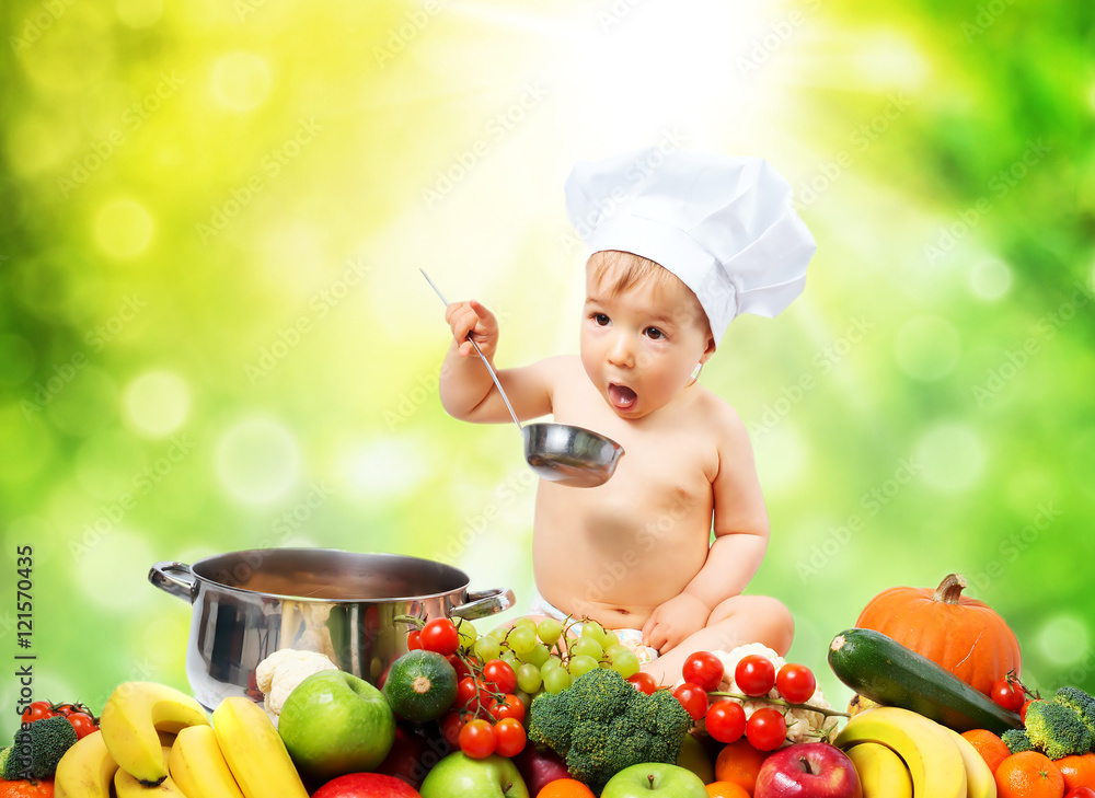 戴厨师帽、带锅和蔬菜的男婴