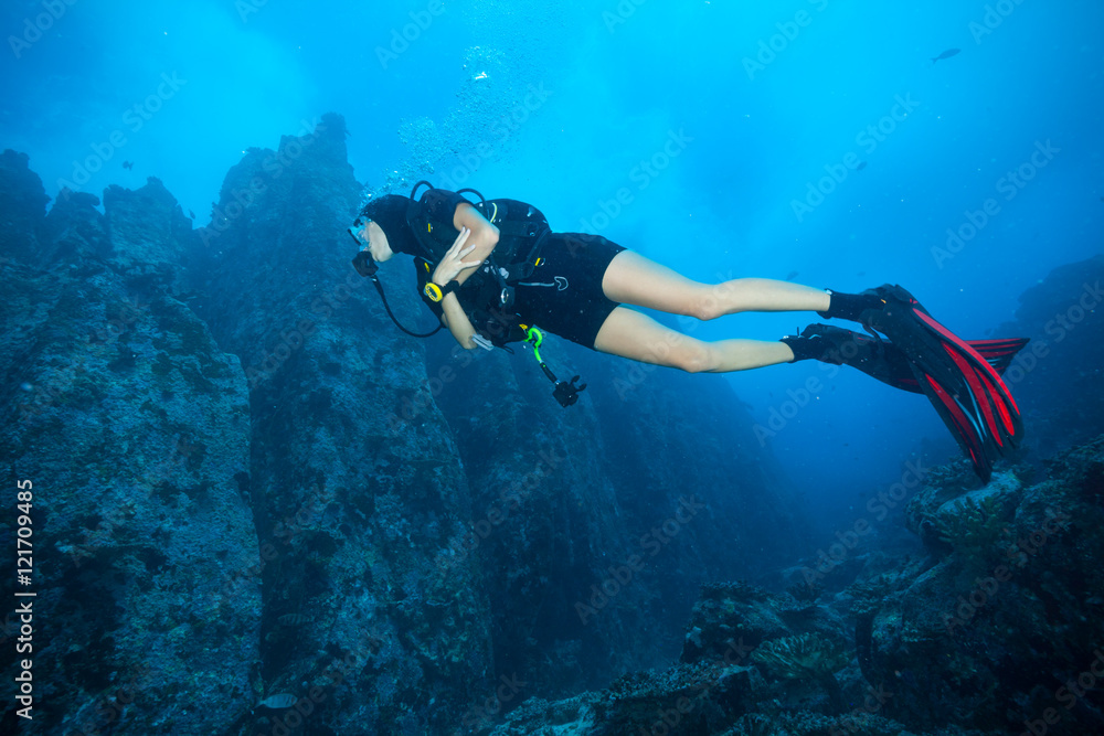 年轻女子水肺潜水员探索海底
