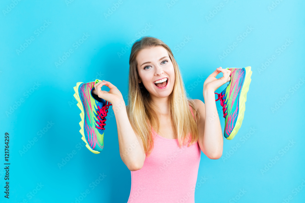 快乐的年轻女人拿着鞋子