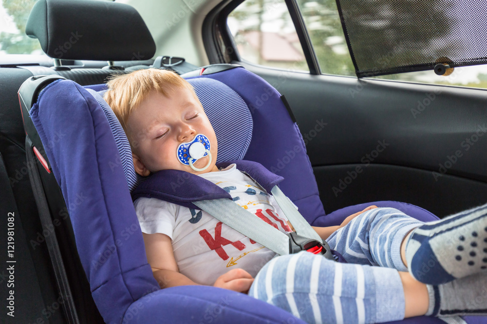 小男孩睡在汽车安全座椅上