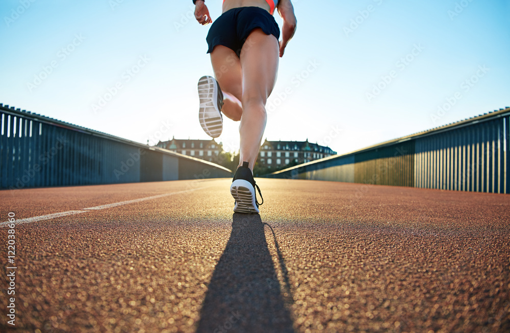 女性慢跑者向前跳跃的低角度视图