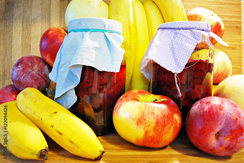 木制背景的新鲜水果和罐子