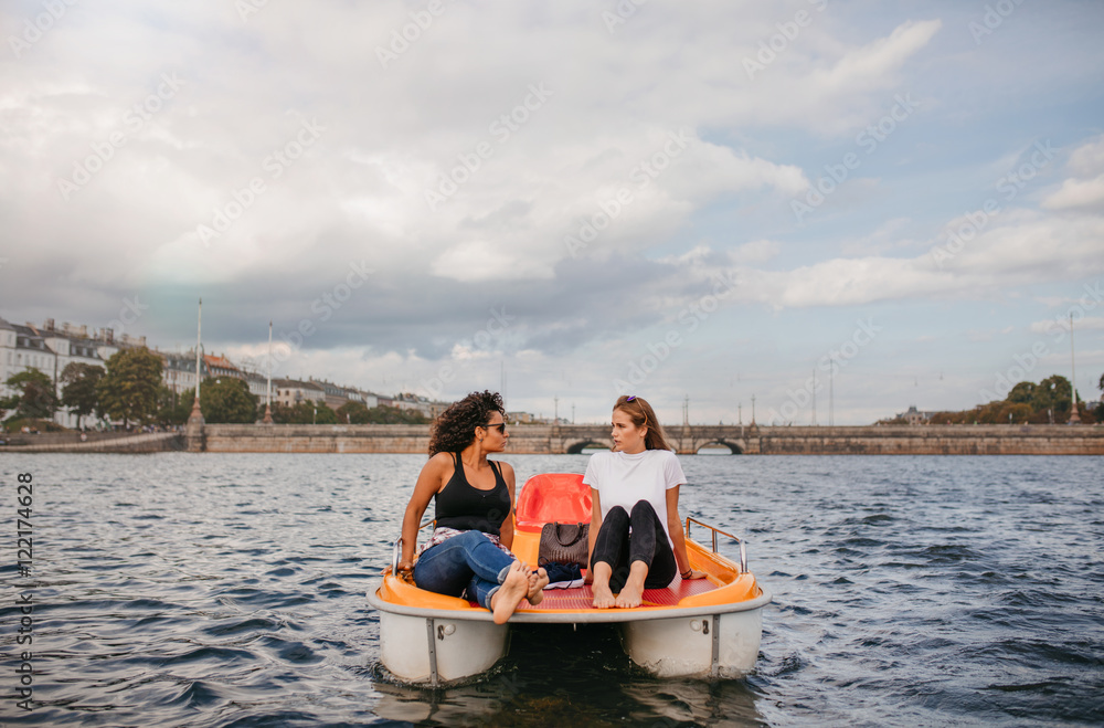 两位年轻的女性朋友坐在前脚踏船上